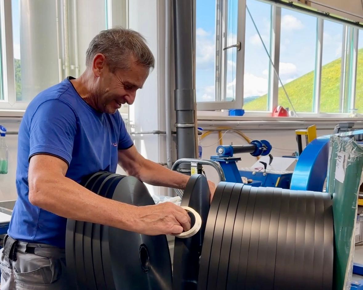 freundlicher Mann in blauem T-Shirt bei der Arbeit mit Blister Gurten