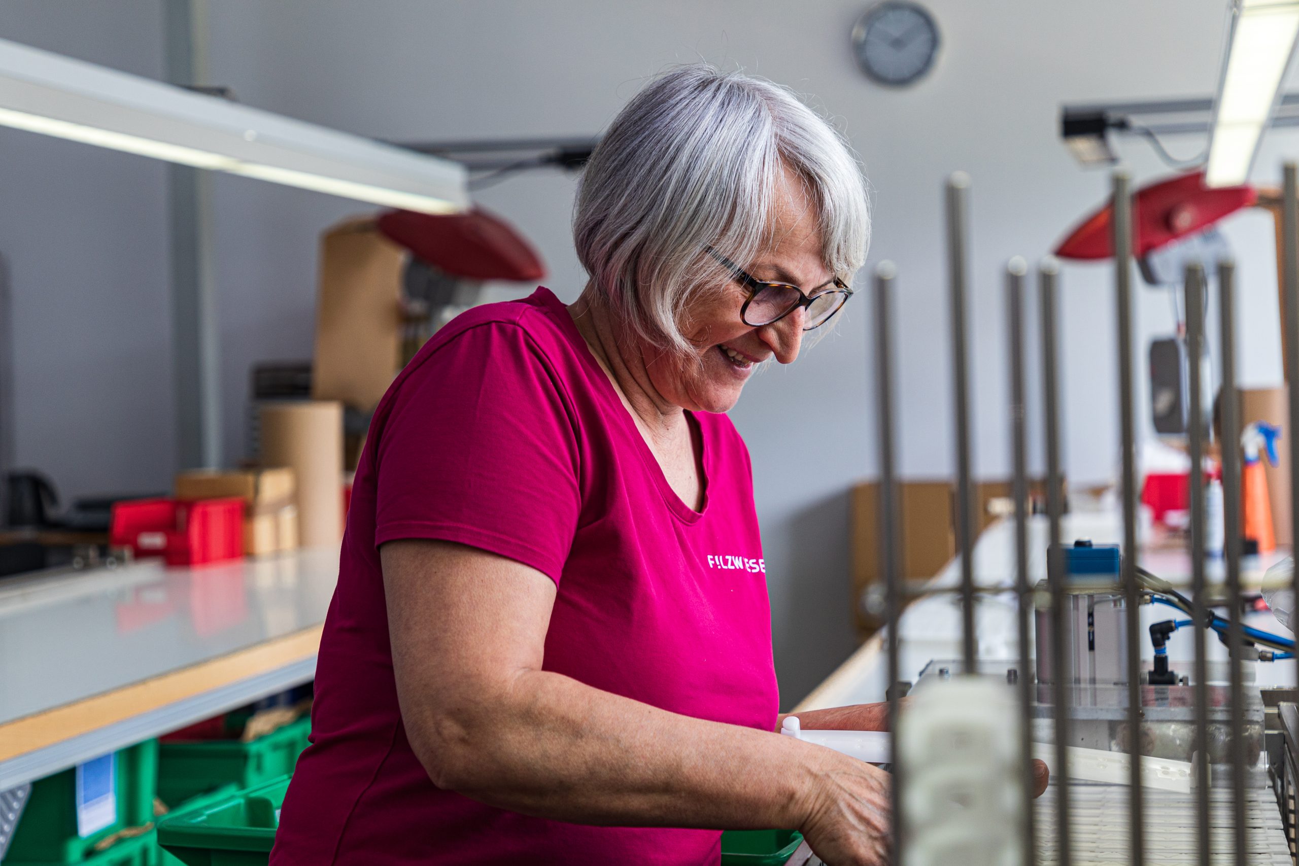 Frau in pinken T-Shirt montiert Kunststoffteile