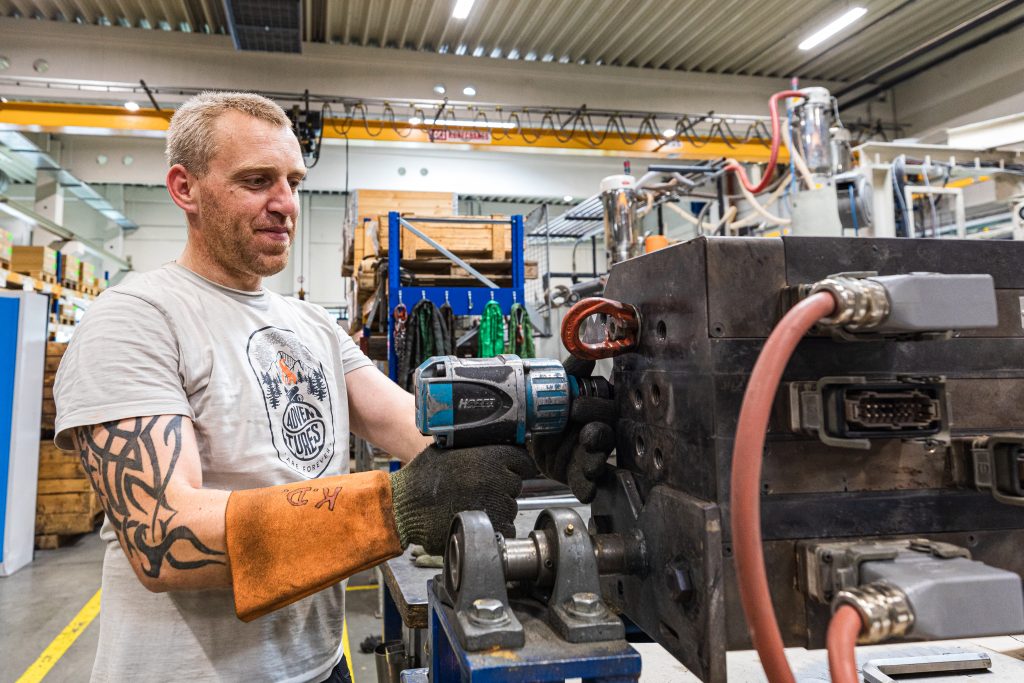 Mann beim säubern eines Extruders