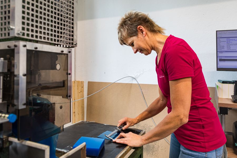 Frau in pinkem T-Shirt bei der Arbeit mit Kunststofffolie