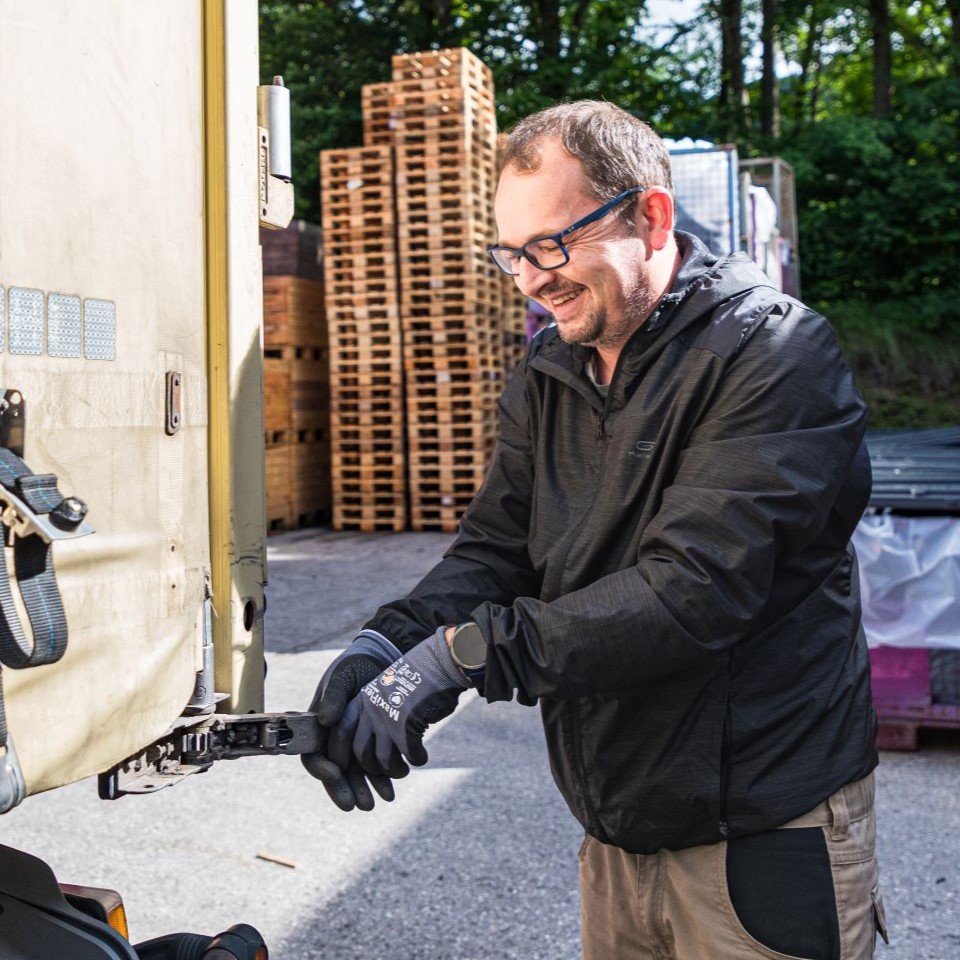 Ein Mann öffnet einen LKW Anhänger