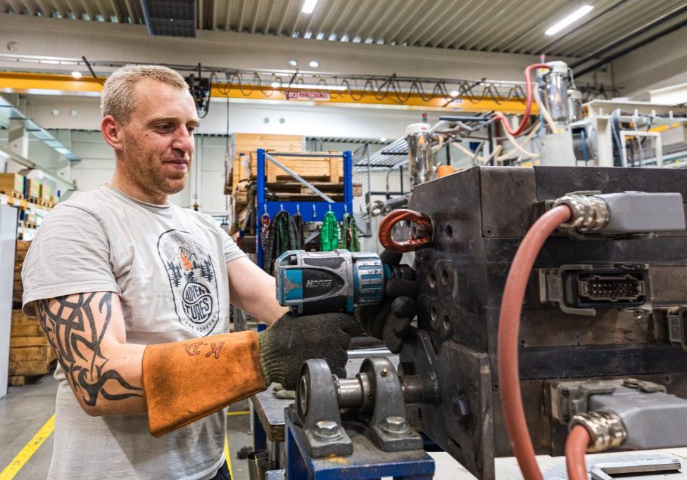 Mann beim säubern eines Extruders